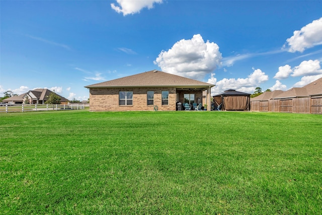 back of house featuring a gazebo and a yard