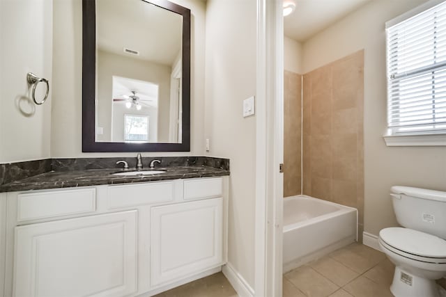 full bathroom with toilet, tile patterned flooring, tiled shower / bath, vanity, and ceiling fan