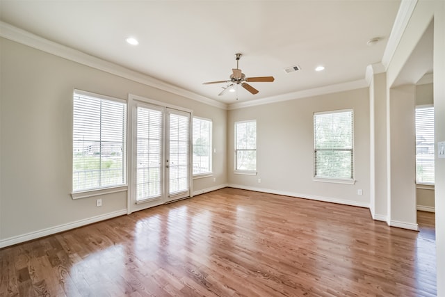 unfurnished room featuring hardwood / wood-style floors, ceiling fan, ornamental molding, and a healthy amount of sunlight