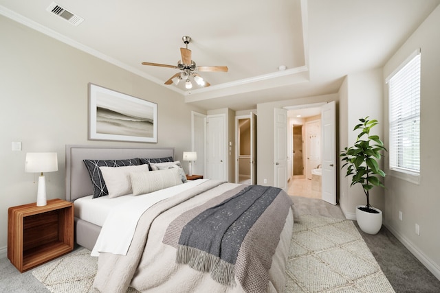 carpeted bedroom featuring crown molding, ceiling fan, and ensuite bath