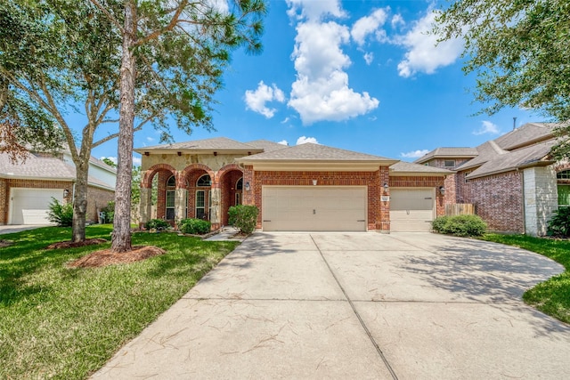 view of front of home featuring brick siding, a shingled roof, a front lawn, a garage, and driveway