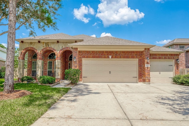 view of front of house featuring a garage, brick siding, and driveway