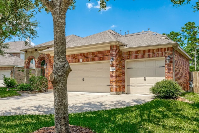 view of front of home featuring brick siding, an attached garage, driveway, and roof with shingles