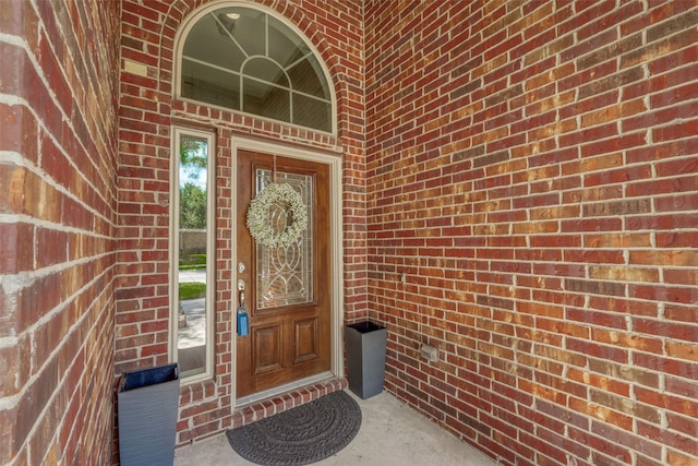 entrance to property featuring brick siding