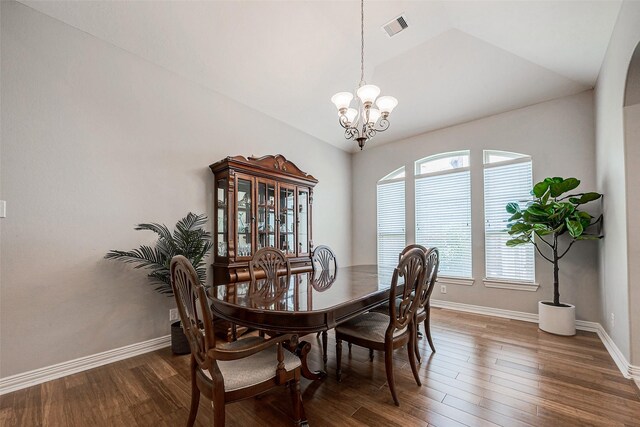 dining room with vaulted ceiling, dark hardwood / wood-style floors, and a notable chandelier