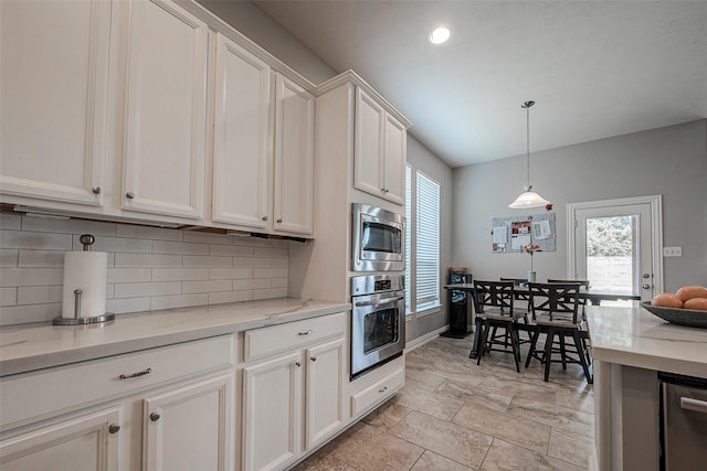 kitchen featuring hanging light fixtures, decorative backsplash, appliances with stainless steel finishes, and white cabinetry