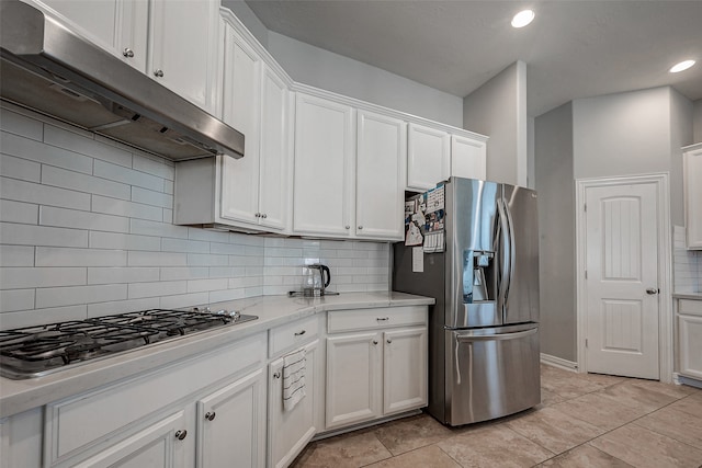 kitchen featuring white cabinetry, light stone counters, stainless steel appliances, and tasteful backsplash