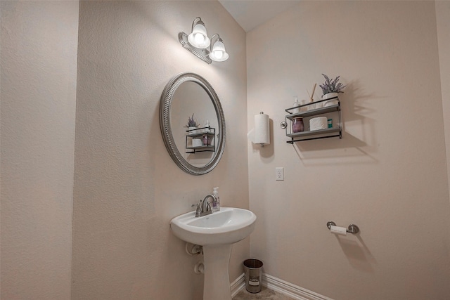 bathroom featuring a sink and baseboards