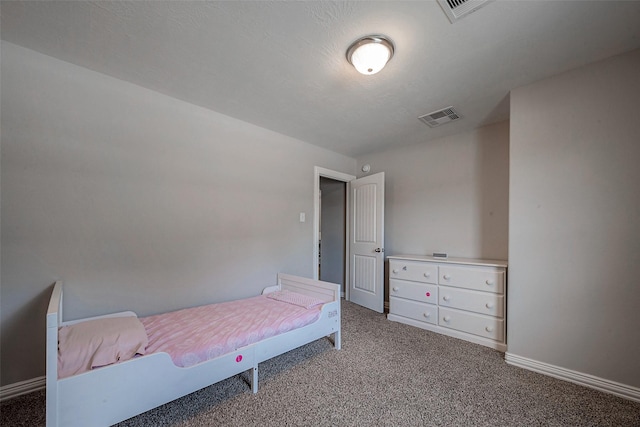 carpeted bedroom featuring baseboards, visible vents, and a textured ceiling