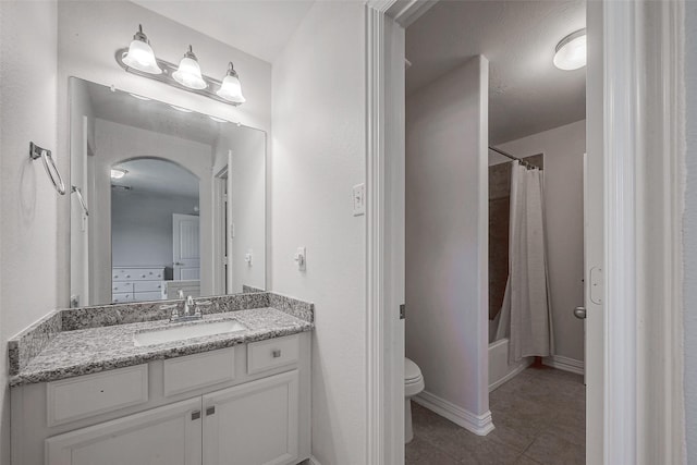 full bath with tile patterned floors, toilet, shower / tub combo with curtain, baseboards, and vanity