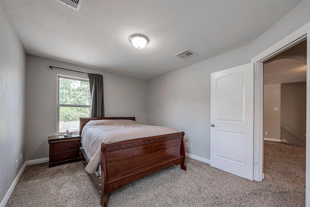 bedroom with arched walkways, visible vents, baseboards, and carpet