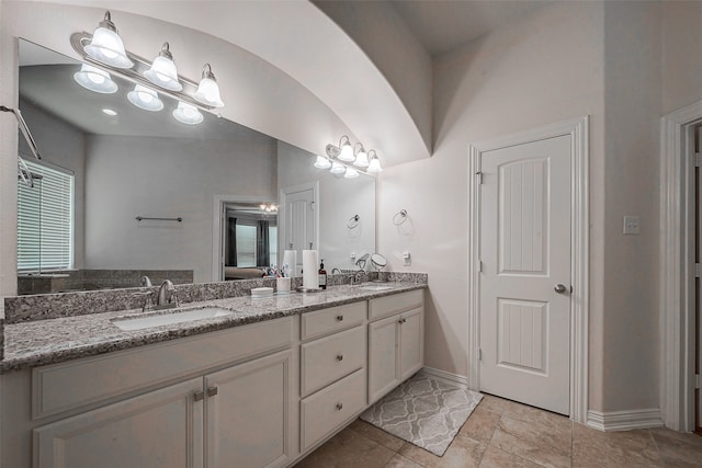 bathroom with a wealth of natural light, vanity, and vaulted ceiling