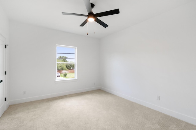 empty room featuring light colored carpet and ceiling fan