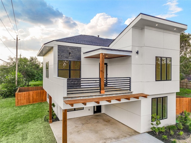 view of front of home featuring a front yard and a balcony