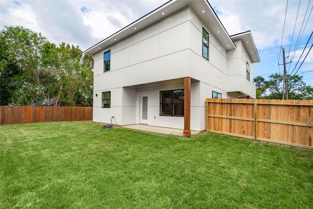 back of house featuring a patio area and a lawn