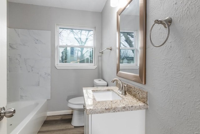 full bathroom with hardwood / wood-style flooring, vanity, shower / bath combination, and toilet