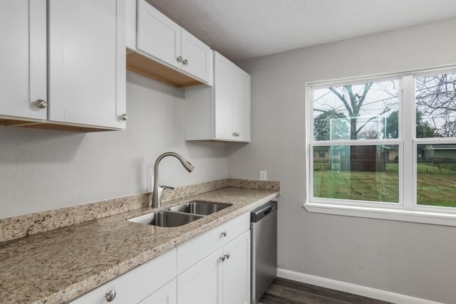 kitchen featuring dishwasher, white cabinetry, sink, dark hardwood / wood-style flooring, and light stone counters