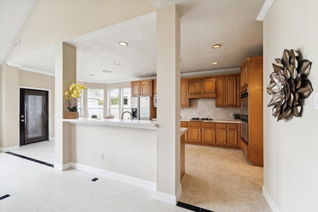 kitchen featuring light tile patterned floors, appliances with stainless steel finishes, kitchen peninsula, decorative backsplash, and ornamental molding