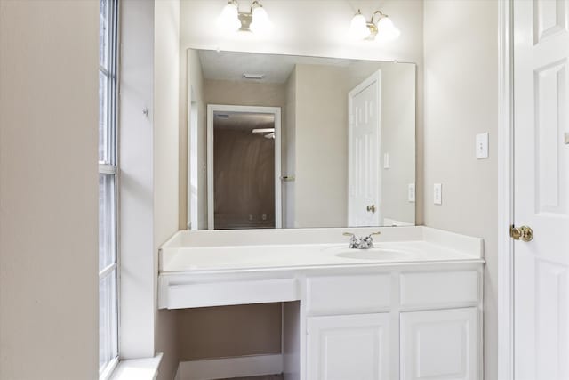 bathroom featuring vanity, a healthy amount of sunlight, and an inviting chandelier