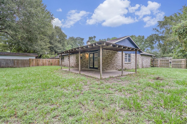 rear view of property featuring a patio, a fenced backyard, brick siding, french doors, and a lawn