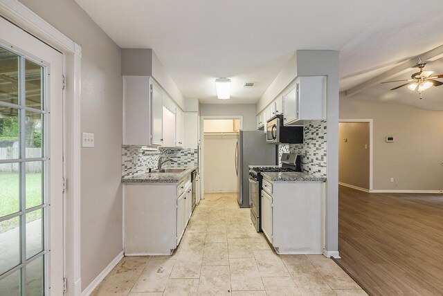 kitchen with backsplash, light wood-type flooring, appliances with stainless steel finishes, white cabinetry, and ceiling fan