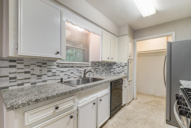 kitchen featuring stainless steel gas range oven, dishwasher, backsplash, white cabinetry, and a sink