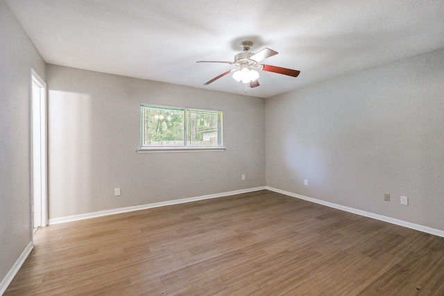 empty room featuring light wood-style floors, baseboards, and a ceiling fan