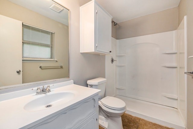 bathroom featuring vanity, toilet, walk in shower, and tile patterned flooring