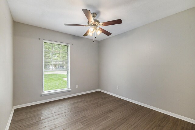 empty room with ceiling fan and dark hardwood / wood-style floors