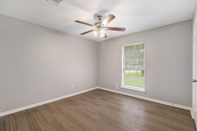 unfurnished room featuring a ceiling fan, dark wood-style flooring, visible vents, and baseboards