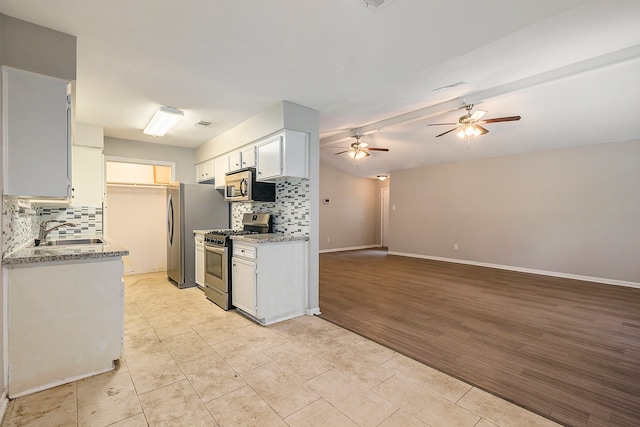 kitchen featuring appliances with stainless steel finishes, light hardwood / wood-style floors, tasteful backsplash, ceiling fan, and white cabinets