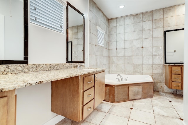 bathroom with vanity, tile walls, a relaxing tiled tub, and tile patterned flooring