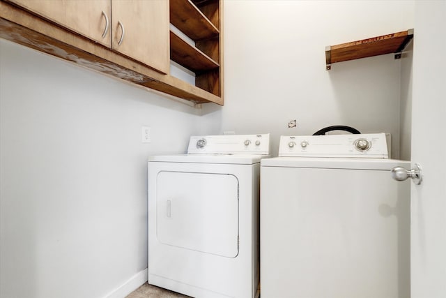 clothes washing area featuring cabinets and washing machine and dryer