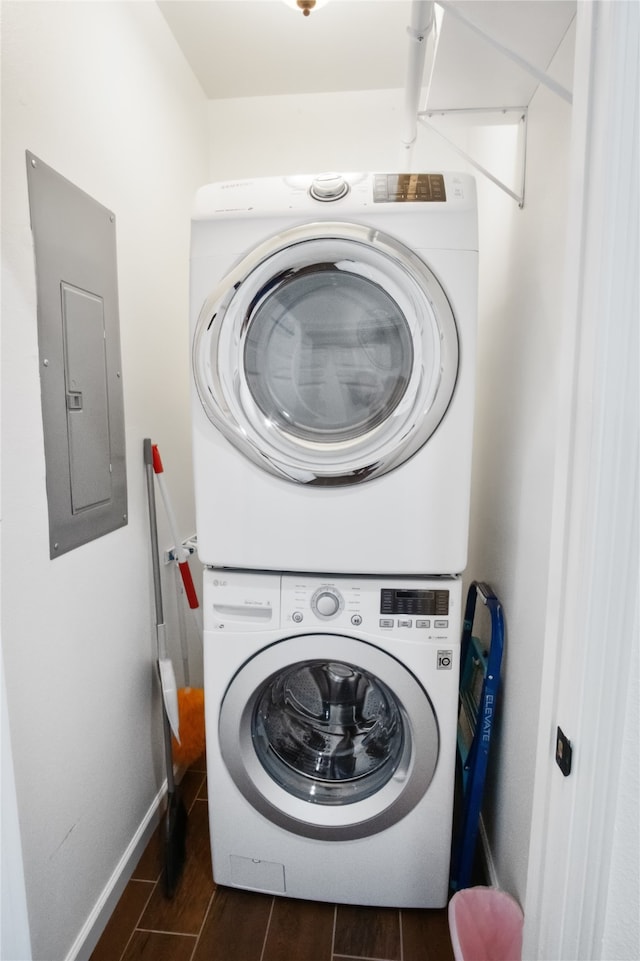 washroom featuring stacked washer and clothes dryer and electric panel