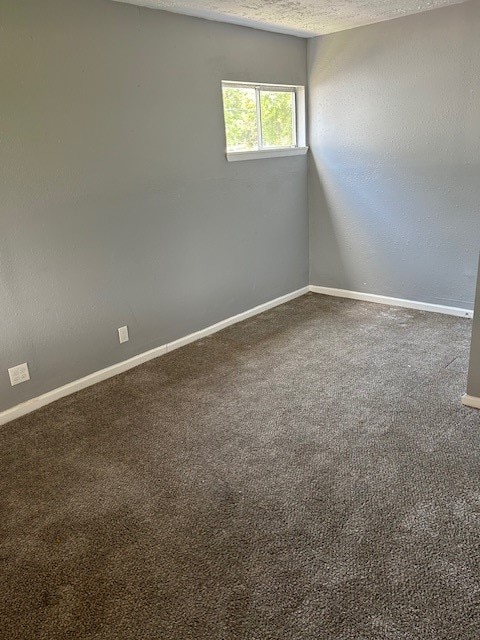 carpeted spare room with a textured ceiling