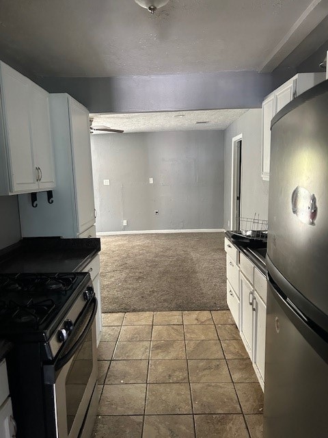 kitchen with carpet flooring, stainless steel appliances, and white cabinetry