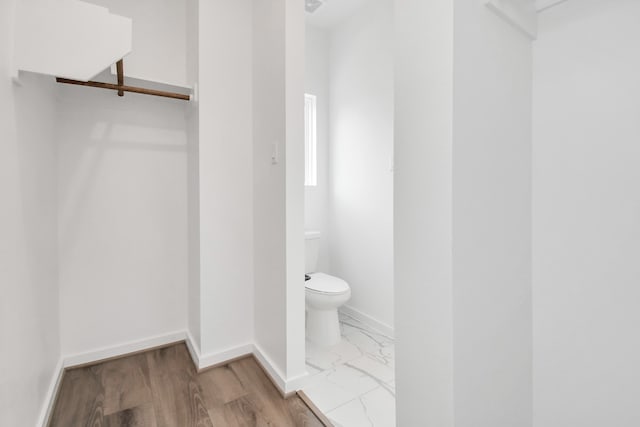 bathroom with hardwood / wood-style floors and toilet