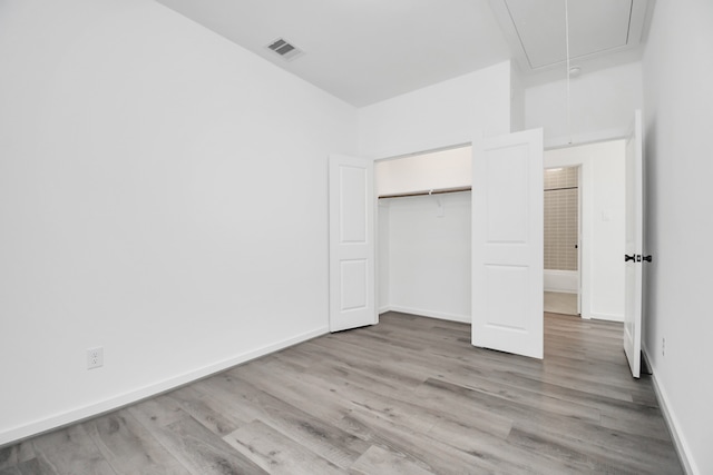 unfurnished bedroom featuring light wood-type flooring and a closet