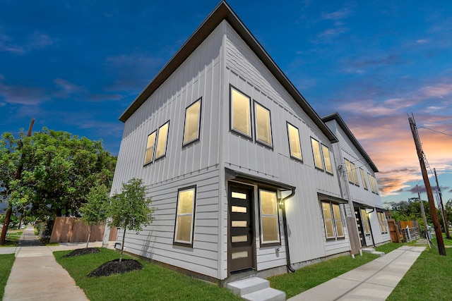 property exterior at dusk with a lawn