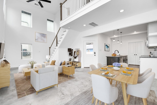 dining room featuring a high ceiling, ceiling fan, and sink