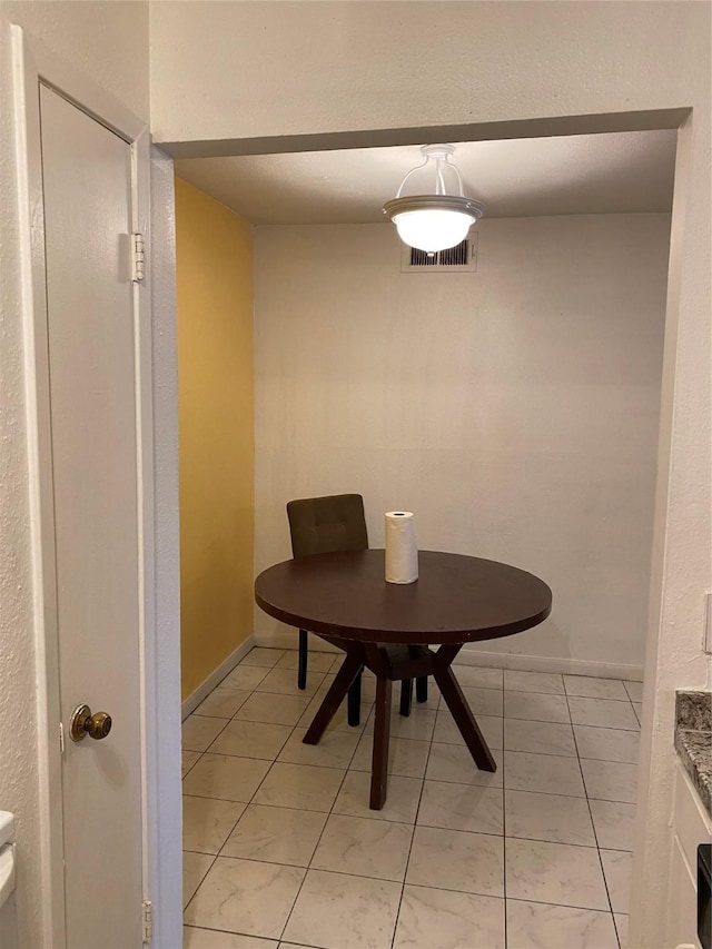 dining area featuring light tile patterned flooring, visible vents, and baseboards