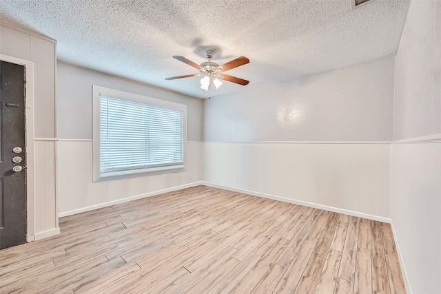 unfurnished room featuring ceiling fan, a textured ceiling, and light hardwood / wood-style flooring