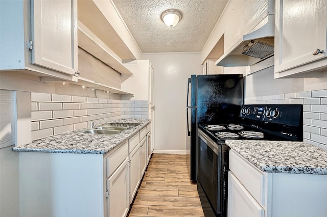 kitchen featuring a textured ceiling, custom range hood, black range with electric stovetop, and white cabinets