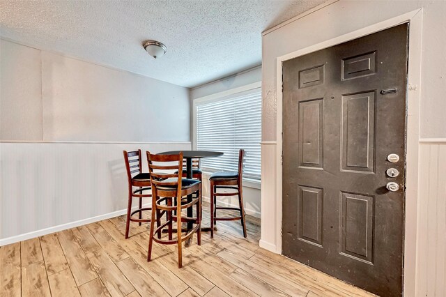 dining room with a textured ceiling and light hardwood / wood-style flooring