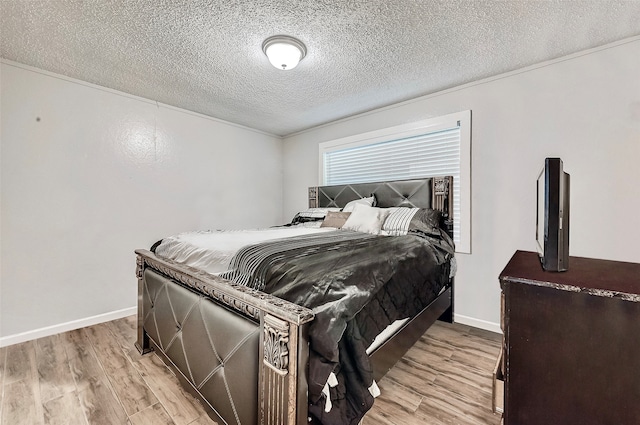 bedroom featuring light hardwood / wood-style floors and a textured ceiling