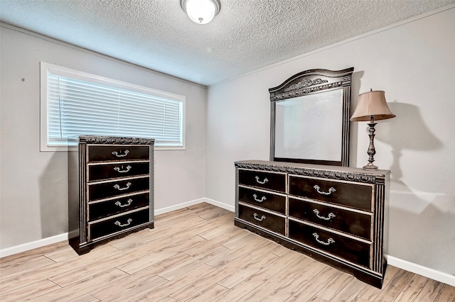 bedroom with a textured ceiling and light hardwood / wood-style flooring