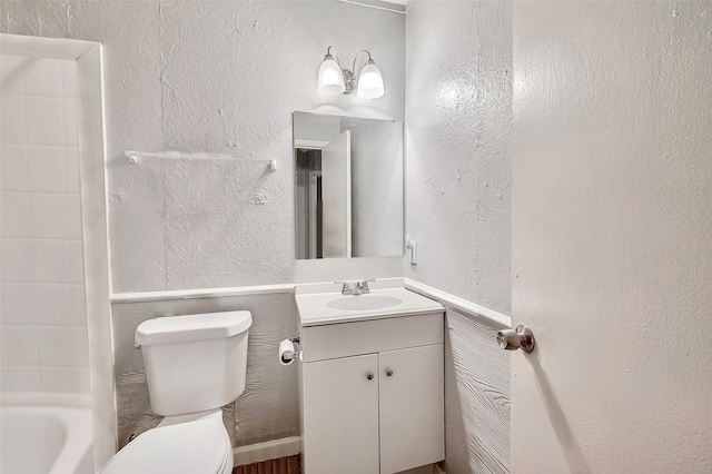 bathroom with vanity, toilet, and tile walls