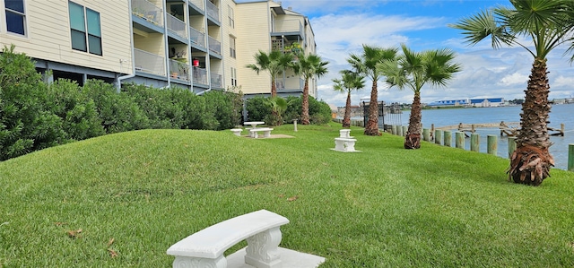 view of property's community with a water view and a yard