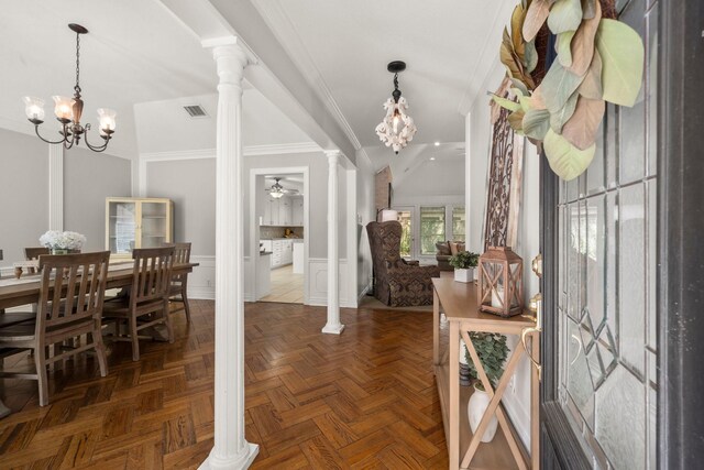 foyer featuring dark parquet flooring, ornate columns, crown molding, lofted ceiling, and ceiling fan with notable chandelier