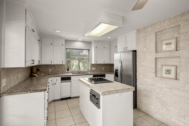 kitchen featuring decorative backsplash, white cabinetry, a kitchen island, and light tile patterned floors